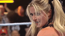 a woman in a wrestling ring with the word n on the bottom left