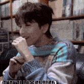 a man wearing a sweater with korean writing on the bottom