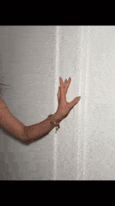 a woman 's hand is reaching out towards a door .