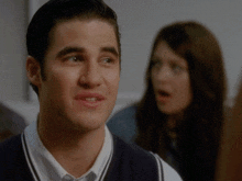 a man with a surprised look on his face and a woman in the background