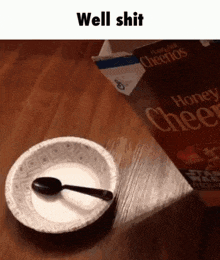 a paper plate with a spoon in it next to a box of honey cheerios
