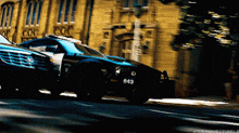 a police car with the number 643 on the front is driving down a street