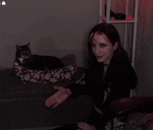 a woman is sitting on a couch with a cat on the couch