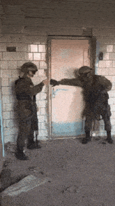 two soldiers are standing in front of a door and one of them is pointing at the door
