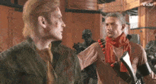 two men are standing next to each other and one has a scarf around his neck ..