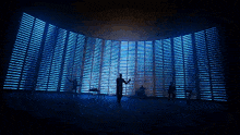 a group of people are standing in front of a wall with blue lights