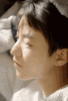 a close up of a person 's face with the sun shining through the window