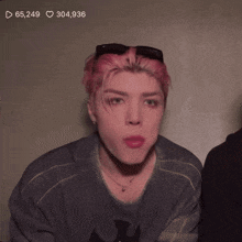 a man with pink hair has 65,249 likes and 304,936 hearts
