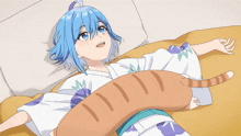 a girl with blue hair laying on a bed with a cat