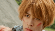 a close up of a person 's face with a few blood spots on it