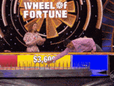 a wheel of fortune game show with a man reaching for a $ 3,604 prize