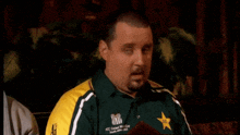 a man with a beard wearing a green and yellow shirt that says icc cricket world cup south africa 2003