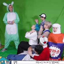 a group of people are sitting in front of a green screen and one of them is wearing a bottle of coca cola d