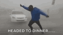 a man is dancing in the fog while a car drives by .