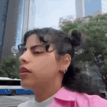a close up of a woman 's face with a pink jacket on