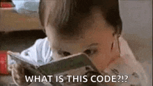 a baby is looking at a book and saying `` what is this code ? ''