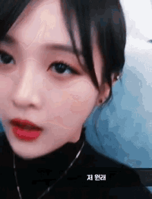 a close up of a woman 's face with korean writing on the bottom right corner .