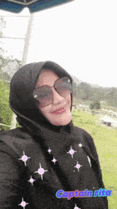 a woman wearing sunglasses and a black scarf with the name captain rita on the bottom