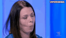 a woman is blowing a kiss on a blue background with the words viperissima on the bottom .