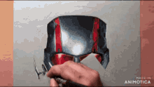 a person is drawing an ant man helmet with a pencil