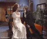 a man in a tuxedo and a woman in a wedding dress are kissing