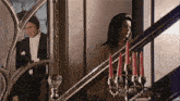 a man and a woman are standing on a set of stairs with candles on them