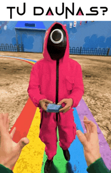 a man in a pink suit with a circle on his face is standing on a rainbow and holding a card