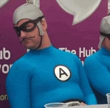 a man in a blue superhero costume with a letter a on his chest