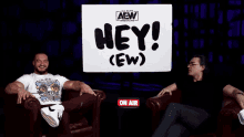 a man is sitting in a chair wearing a wrestling shirt