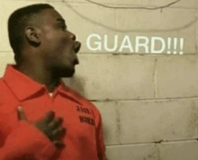 a man in an orange prison uniform shouts guard