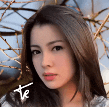a close up of a woman 's face with the letters te on the bottom