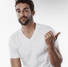 a man with a beard wearing a white t-shirt giving a thumbs up