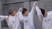 a group of young men wearing white sweatshirts with the word cool on them are dancing together .