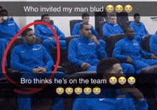 a group of basketball players are sitting in a stadium and one of them is wearing a blue jacket .