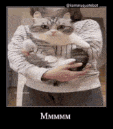 a woman is holding a cat in her arms and the caption says mmmm