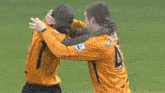 two soccer players are hugging and one has the number 4 on his back