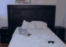 a blurred image of a bed with a laptop and a cell phone on it