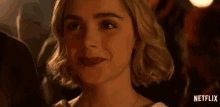 a close up of a woman 's face with a netflix logo behind her .