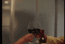 a man and a woman are toasting with wine at a table with petals on it