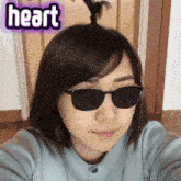 a woman wearing sunglasses has the word heart written on her face