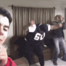 a group of people are dancing in a living room .
