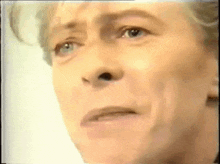 a close up of a man 's face with a slight smirk on his face .