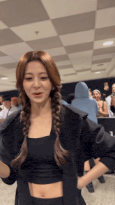 a woman in a braided ponytail is standing in a room