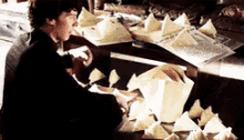 a man is sitting at a table with a lot of papers on it .