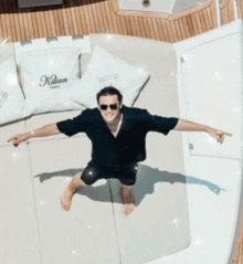 a man is laying on a boat with a pillow that says kilian on it