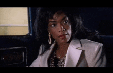 a woman is sitting in the back seat of a car looking out the window .