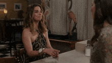 two women are sitting at a table with rude written on it