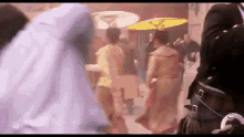 a group of people are dancing in a room with umbrellas in the background .