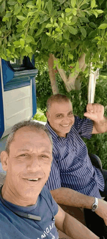 two men posing for a picture with one wearing a shirt that says ' adidas '