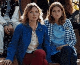 two women wearing blue jackets sit next to each other